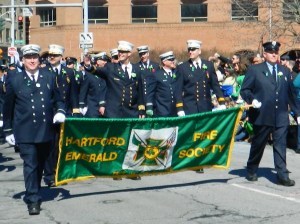 Back from military deployment in Afghanistan and back on the job as deputy chief of the Hartford Fire Department, Dan Nolan (center) marched with the Emerald Society.