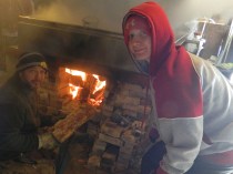Dan and his son Tyler load seasoned wood from their property into the evaporator's burner.