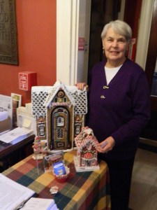 Volunteer Bobbi Cote with a gingerbread house she bought at Lux, Bond & Green.
