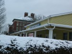 Behind snowy bushes, the army Navy Club in downtown Manchester.