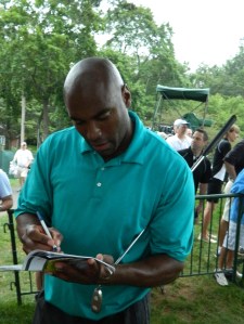 Photo by Jacqueline Bennett  Former UConn and NBA standout Scott Burrell signs autographs  during the Traveler's Championship Pro-Am Day in 2011.
