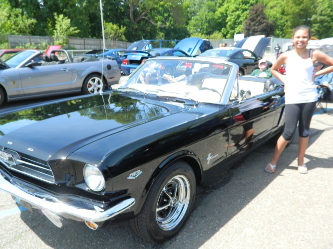 Twelve-year-old Cassidy Jacobs is shown with her grandfather's "1964 and a half" Ford Mustang June 1 at a Mustang Show in Manchester, CT. The model was introduced on April 17, 1964 at the New York's World Fair, the original "pony" car.