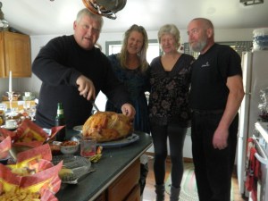 Mike carving the turkey. Beside him are Melane, her sister karen and Karen's husband Danny.