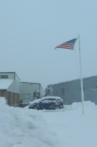 Old Glory whips in the wind outside a Manchester business.