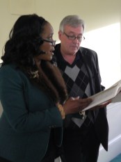 Angela Griffin and T. J. Donohue share a hymn book and sing together "We Shall Overcome."